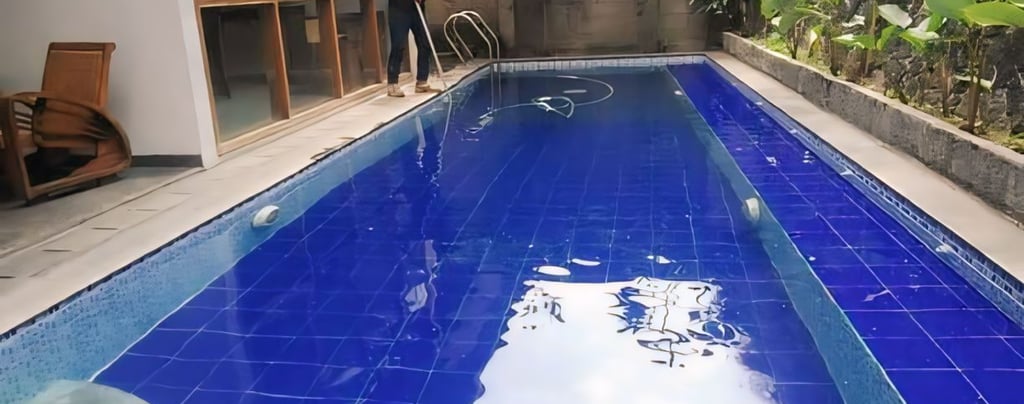 kolam renang sederhana di halaman belakang rumah dengan keramik berwarna biru tua