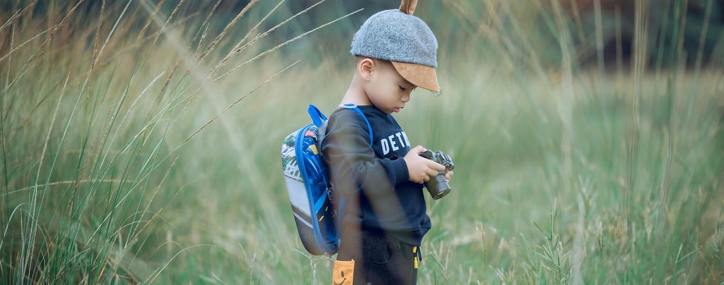 a young boy in a hat and a backpacker
