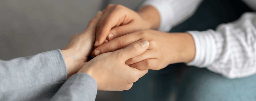 a woman holding a man's hand while he is holding his hand while communicating