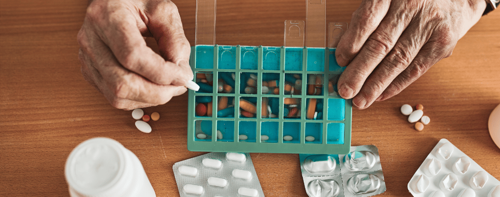 Man Organizing His Medication into Pill Dispenser
