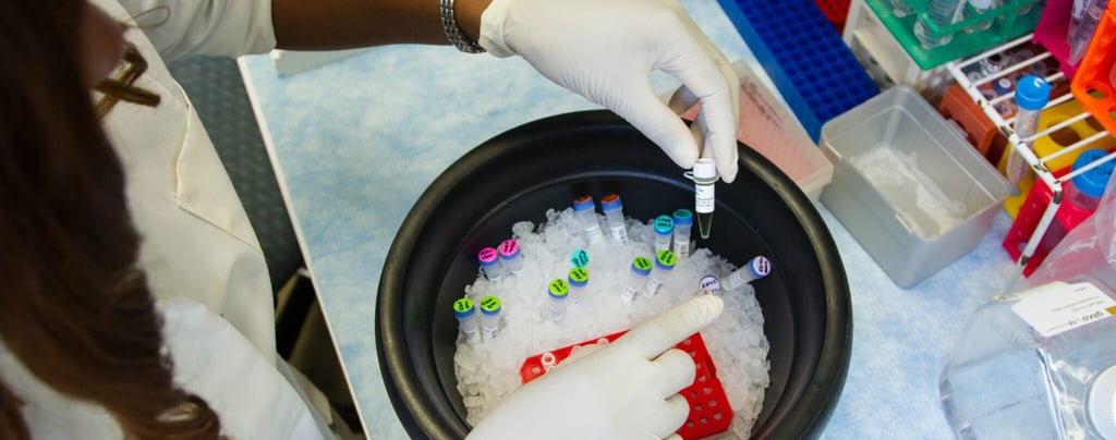 a woman in a lab coat and gloves holding a pipe of liquid