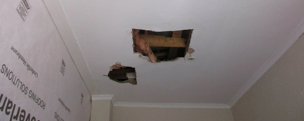Hole in ceiling showing roof board failure