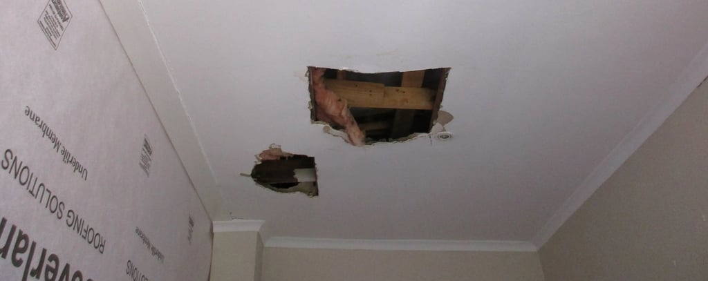 Hole in ceiling showing roof board failure