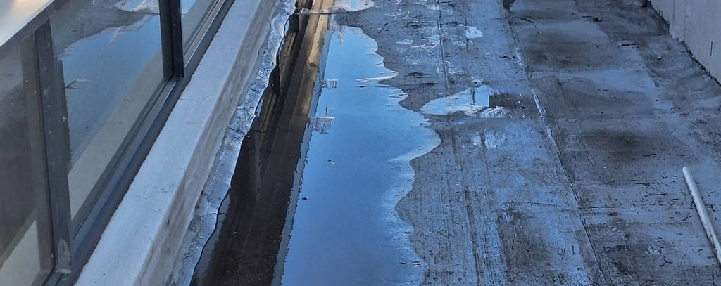 Standing water on flat roof due to poor drainage