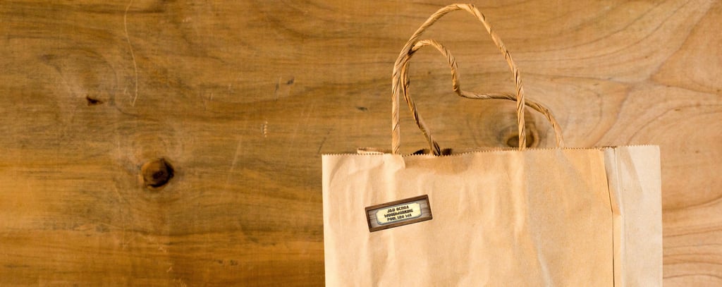 Brown paper shopping bag with J & D Ochoa Woodworking Logo sticker