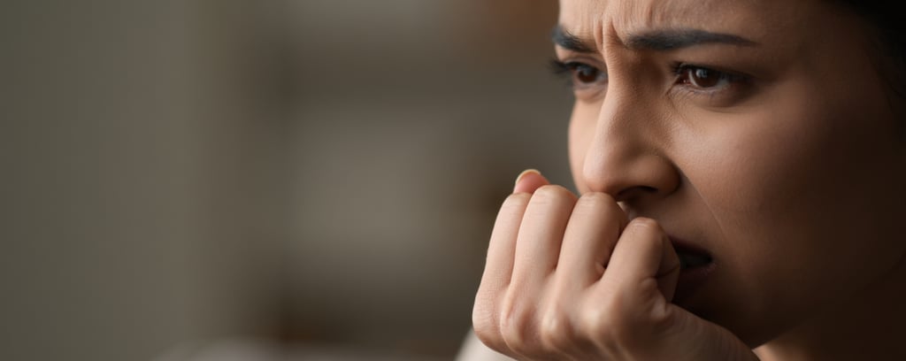 ragazza con una faccia contrariata che cerca di mangiare le unghie 