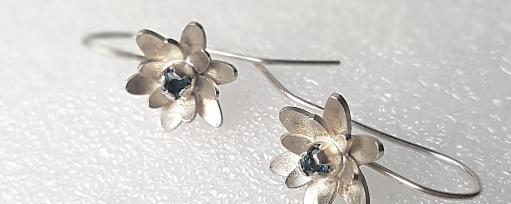 a pair of earrings with a flower design