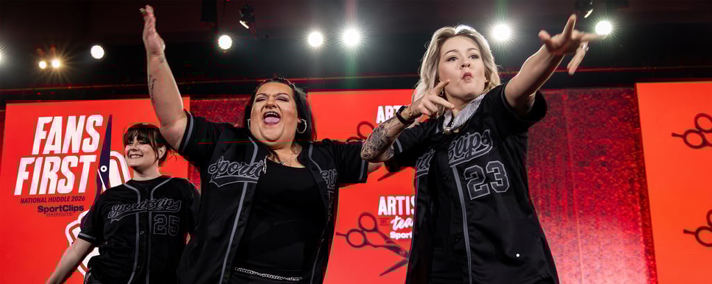 SportClips hairstylists performing on stage during the National Huddle 2024 Fans First artistic team presentation.