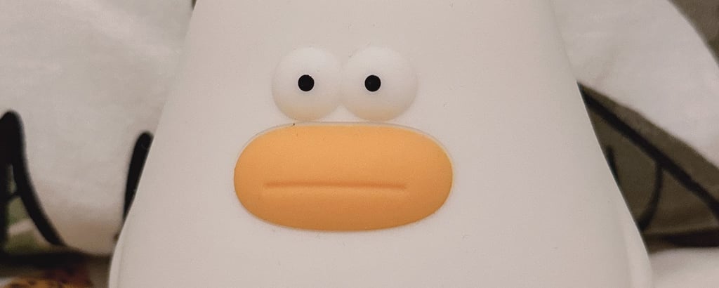 Cute white silicone duck night light for kids, featuring an adorable rounded bird design with an orange beak.