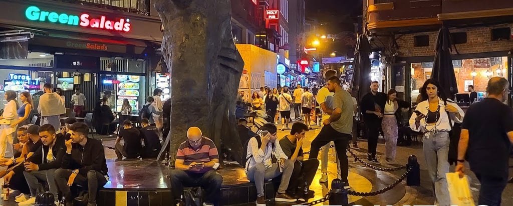 Nächtliches Istanbul mit lebendigen Bars, leuchtenden Lichtern und Menschen, die das pulsierende Nachtleben entlang des Bospo