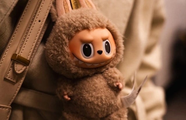 Labubu plush keychain handing from a backpack