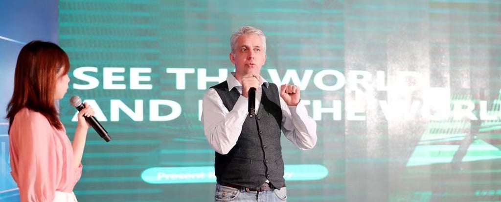 a man and woman standing in front of a large screen