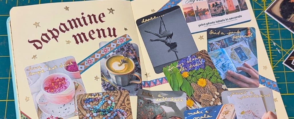 A journal showing creative dopamine menu ideas with photo sticker labels and hand-drawn stars on a green cutting mat..