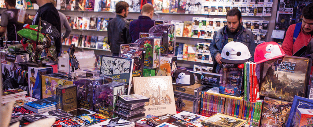 a bunch of people standing around a table with a lot of toys