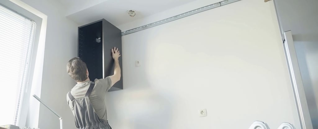 Mężczyzna montuje korpus szafki wiszącej za pomocą listwy montażowej 