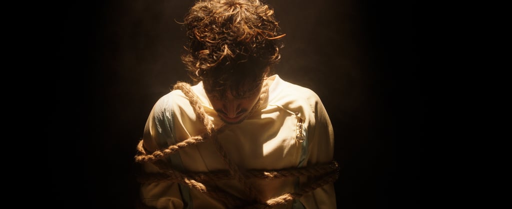 a man in a white shirt is tied up and tied up