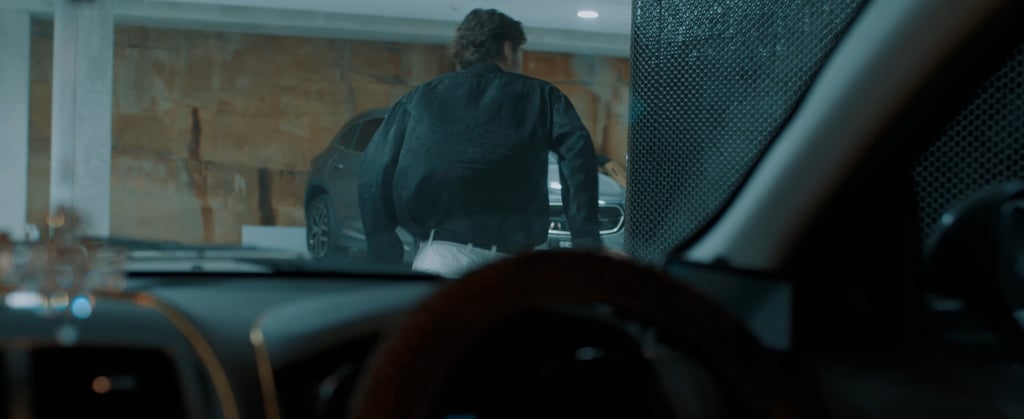 a man in a black jacket is standing in front of a windscreen