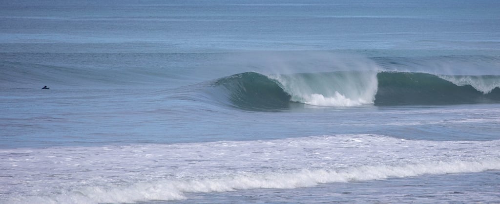 A perfect unridden pick wave with a surfer behind ready to catch another great wave