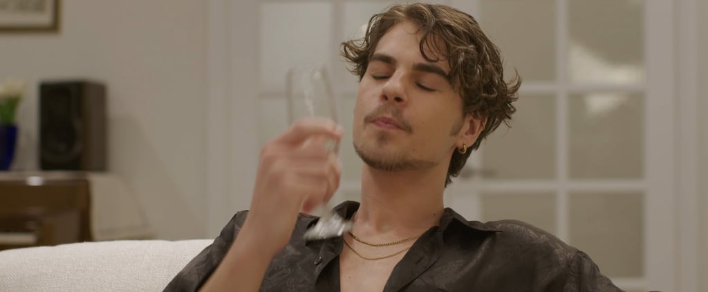 a man with a glass sitting on a couch