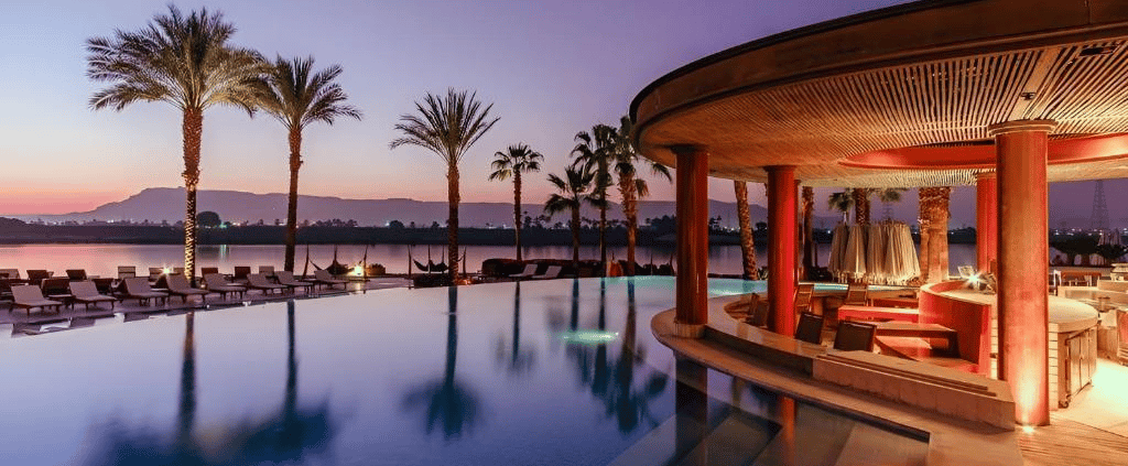 Hilton Luxor Resort & Spa infinity pool with a swim-up bar and palm trees.