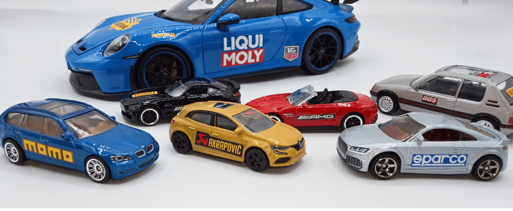 Plusieurs voitures miniatures de tailles différentes , personnalisées avec des décalcomanies.