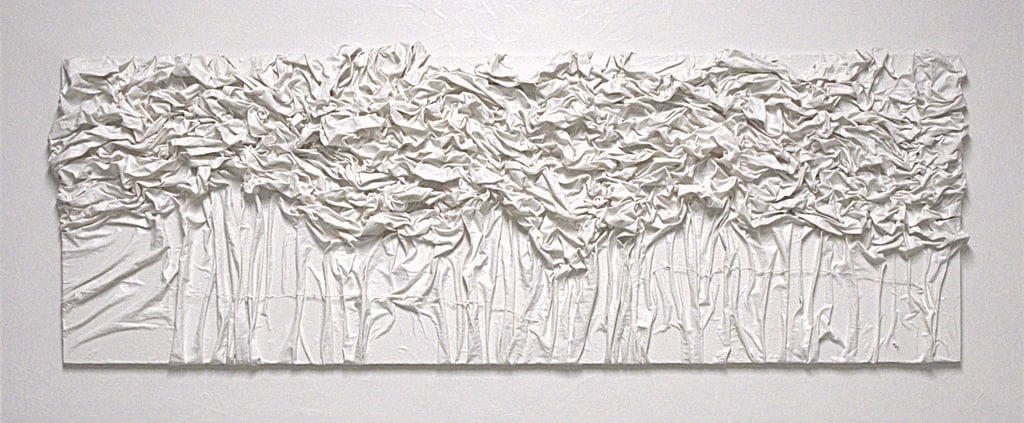 Textured white monochromatic 3D canvas wall art with draped fabric and ruffled abstract details.