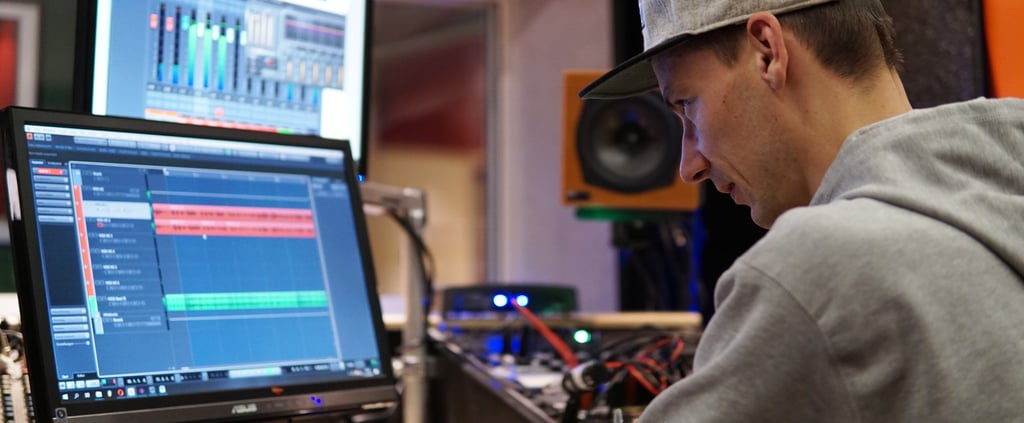 a man professionally masters music in a studio on a computer