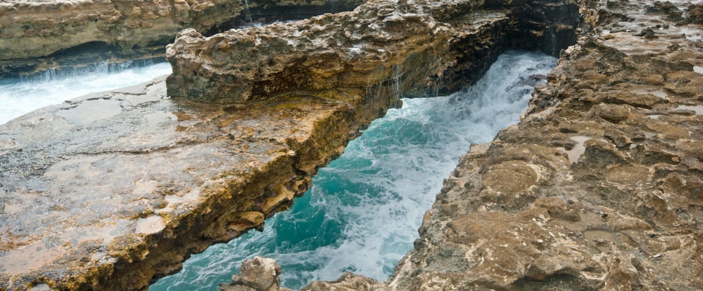 vista de perto da Devil’s Bridge em Antígua com o mar batendo nas rochas abaixo