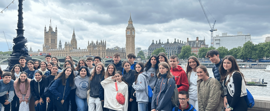 Un grupo de estudiantes en un viaje escolar a Londres posando frente al Big Ben y al Parlamento.