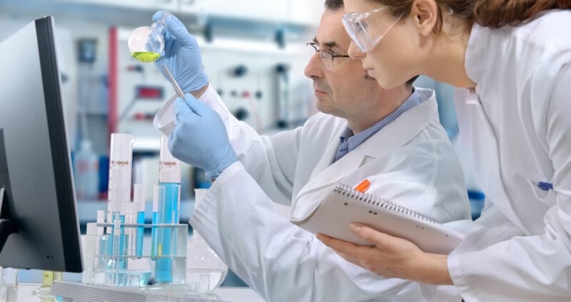 a man and woman in lab coats and gloves