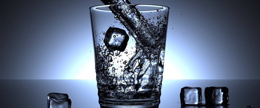 Pouring Water in Glass and Ice Cubes