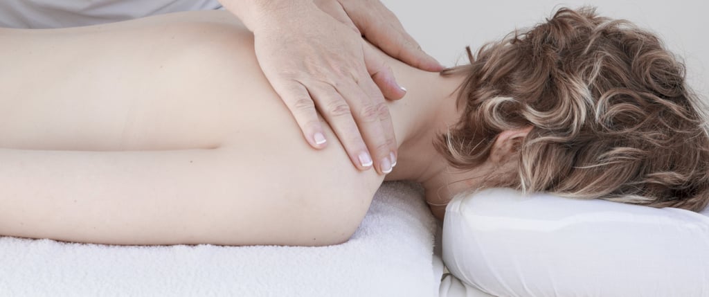Professional massage therapist performing a deep tissue neck and shoulder massage for relaxation.