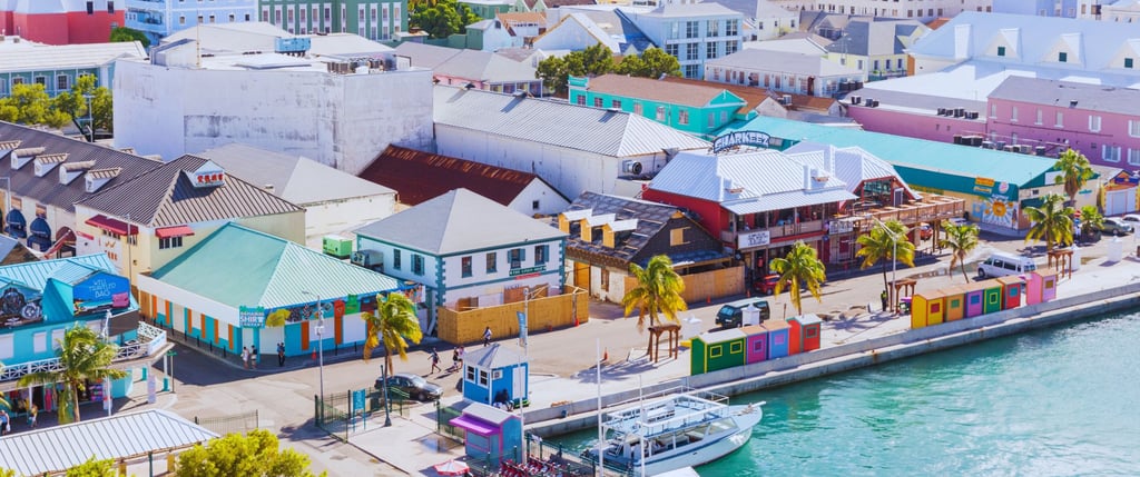 Vista do navio chegando ao porto de Nassau, nas Bahamas, com águas cristalinas e a cidade ao fundo, 