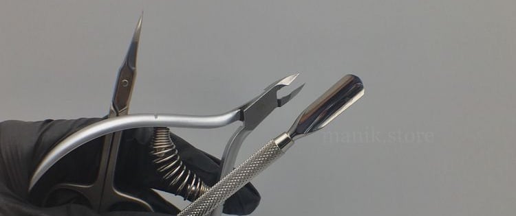 mano con guanto che regge 3 attrezzi spingicuticole forbicine e tronchesine acciaio inox