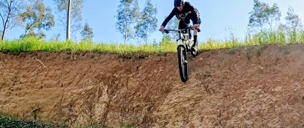 mtb rider riding down a steep roll in