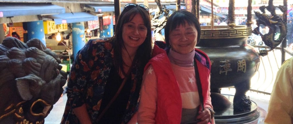 Autora posando com uma senhora local no templo Qingan, em Keelung.
