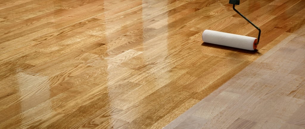 Brand new hardwood flooring is being finished with a roller. Showing raw and finished hardwood.