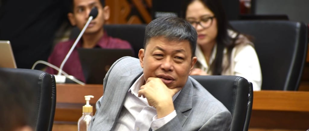 a man in a suit and tie sitting at a table