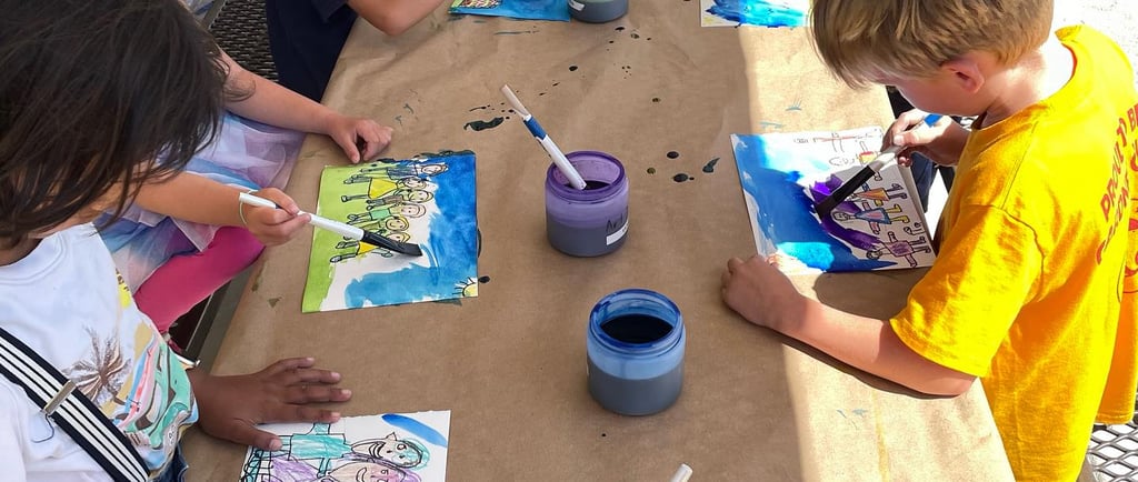 children applying watercolor wash to a drawing