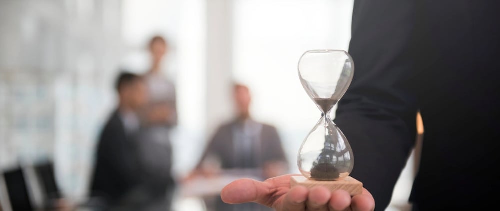 a man in a suit and tie is holding a hourglass hourglass hourglass
