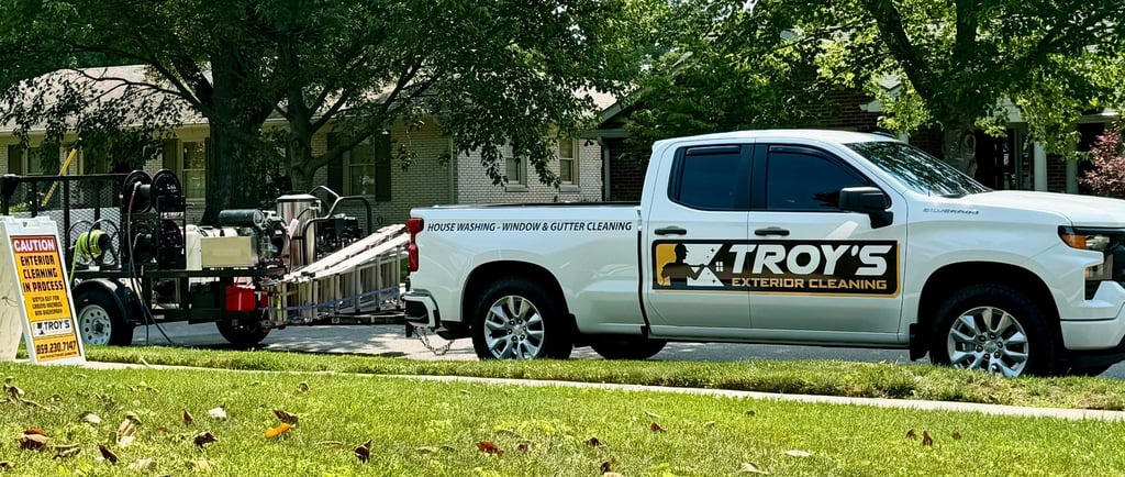 White truck with Troys Exterior cleaning logo and pressure washing trailer in tow