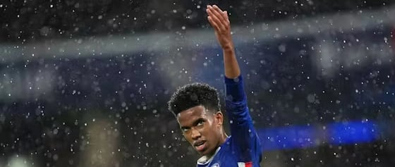 a man in a blue shirt is holding a soccer ball