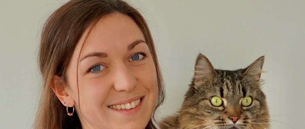 a woman in a red shirt is holding a cat