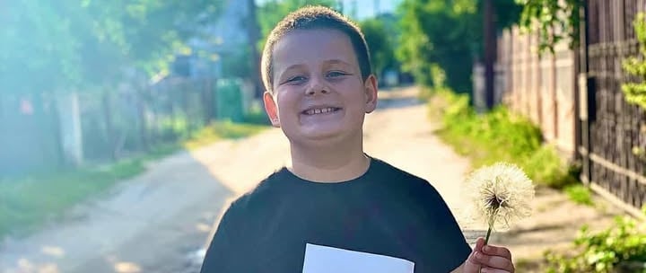  хлопчик, який тримає кульбабку