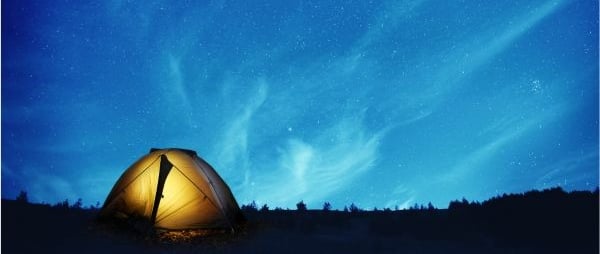 tienda de campaña frente a un cielo estrellado