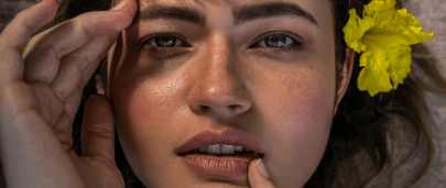 Close-up of a person with healthy, glowing skin, natural dewy texture, and a calm expression