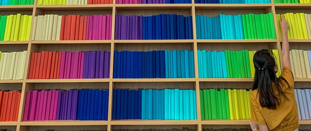 a woman standing in front of a large bookcase