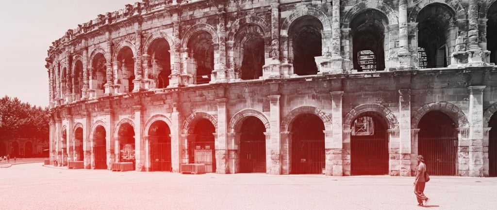 a man standing in front of a large colliseum arena