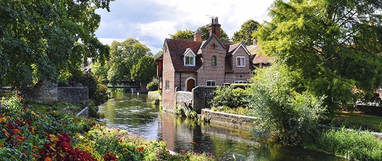 Maison en brique rouge sur les bord de la riviere Great Stour à Canterbury bordée de fleurs