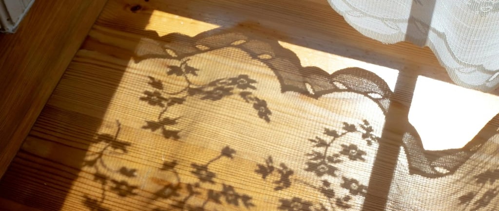 Soft sunlight casting curtain shadows, capturing Jahida's childhood memory of magical sunlit dust.